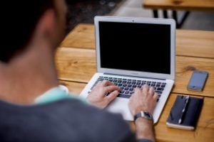 man typing on laptop